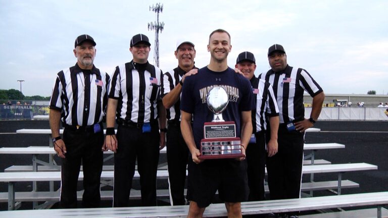Sam Schlegel holds the trophy with officials