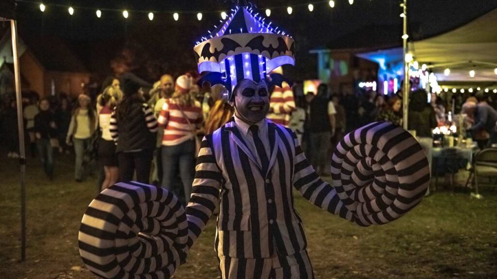 Person in black and white light-up costume at Howlin' at the Moon