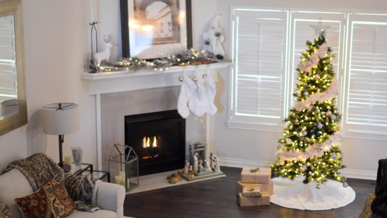 Clean living room decorated for holidays with Christmas tree and lit fireplace