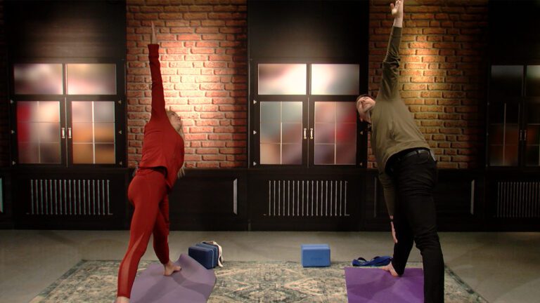 Nathan Ronchetti of 630 Naperville does yoga pose with yoga instructor
