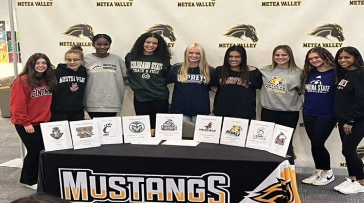 Metea Valley athletes pose for photo on early National Signing Day
