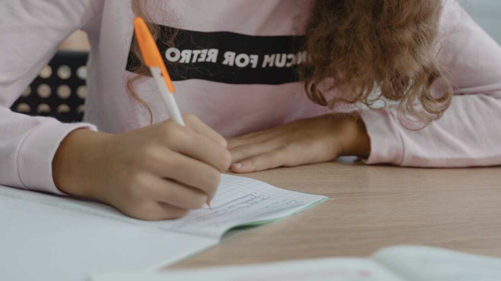 Close up of student writing in notebook