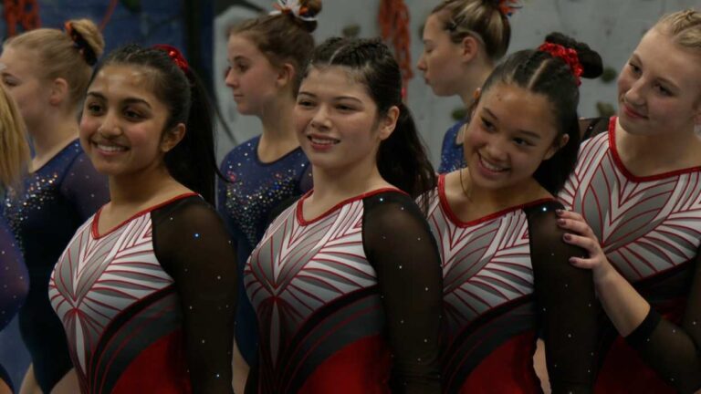 Naperville Central gymnast Gabi Tapia and her teammates smile before the meet.