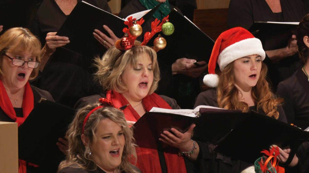 Naperville Chorus members sing in christmas themed hats and headbands