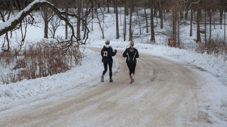 Two people running in the snow for the Pine Pacer challenge