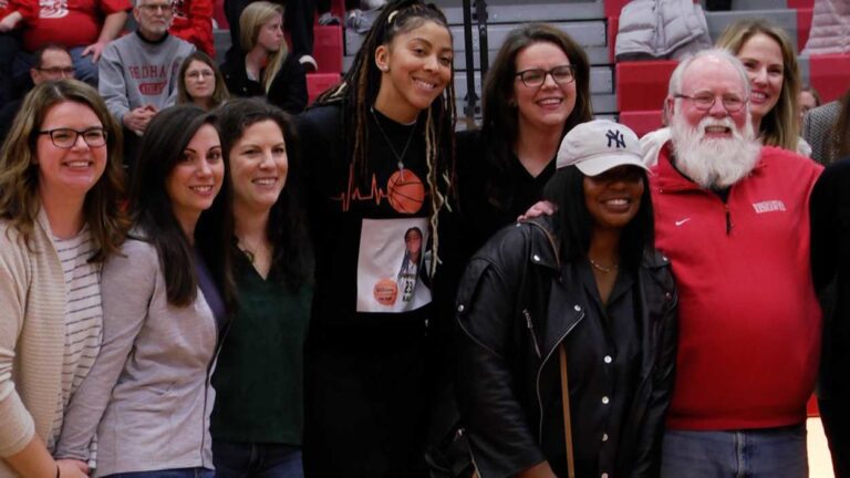 Candace Parker and other Naperville Central alumni smile at mid-court during the anniversary celebration.