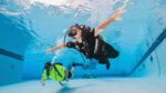 Diveheart participant scuba dives with instructor in a pool