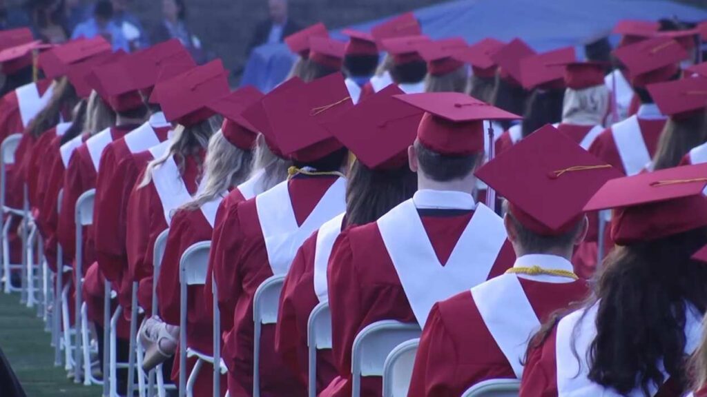 Naperville School District 203 graduates seated in caps and gowns at graduation
