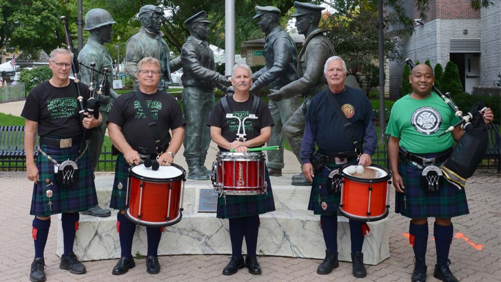 Members of the West Suburban Irish wear traditional Irish garb and hold drums and bagpipes in front of Central Park in Naperville