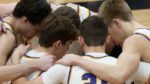 Downers Grove North boys basketball in a huddle before the game