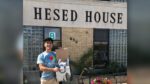 Man holds up donations in front of Hesed House