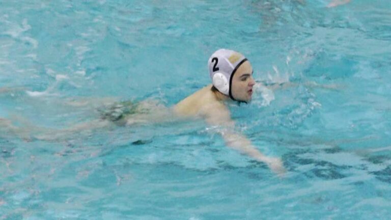 Metea Valley’s Matthew Henkle swims away after scoring.