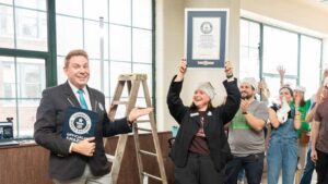 Woman holding underwear wearing record certification from Guinness