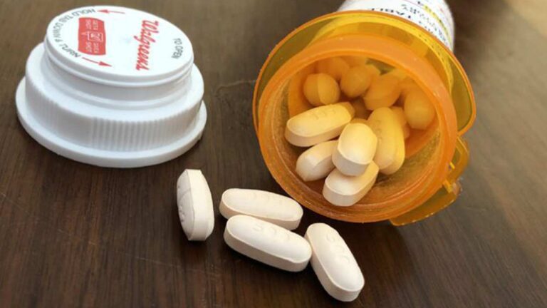 pills and pill bottle of opioids on table for story on overdose deaths