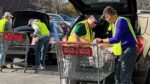 Loaves and fishes volunteers load groceries into a vehicle.