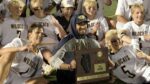 Neuqua Boys lacrosse players celebrate after beating Libertyville with the IHSA Super Sectional plaque.