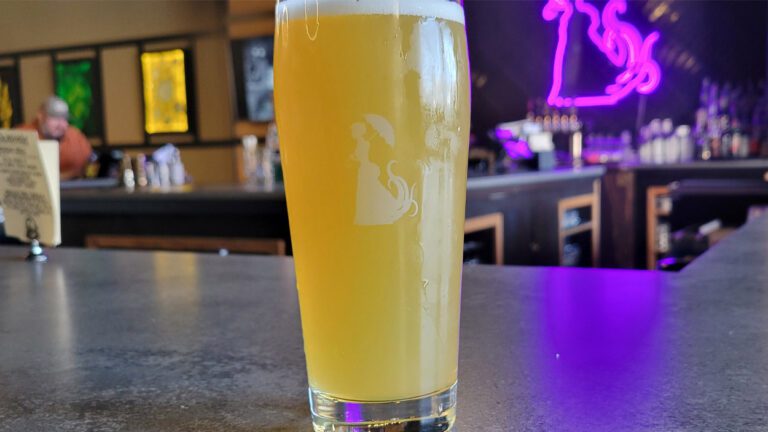 A pint glass sits on the bar in Miskatonic Brewing Craft Kitchen.