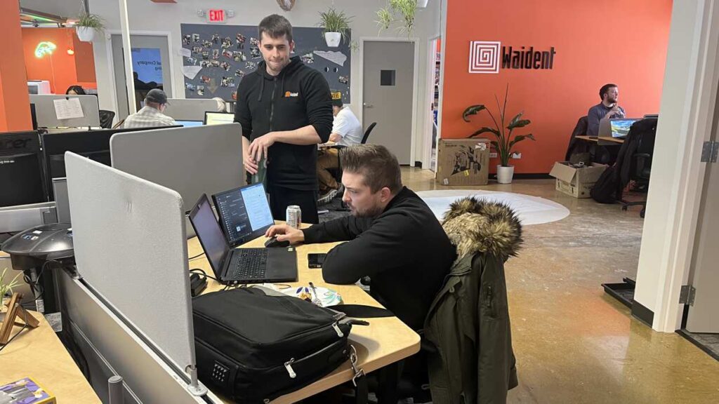 Employees at Waident Technology Solutions in Naperville working on computer at desk in office space