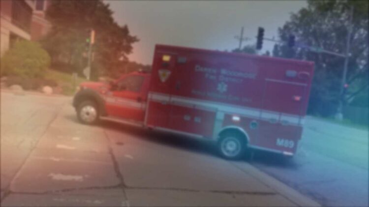 Blurred image of ambulance for story about woman killed in crash