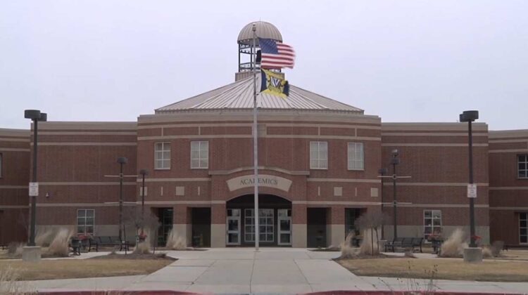 Wide shot of academics building at Neuqua Valley High School with flagpole in front -one of the 204 schools to have work done this summer