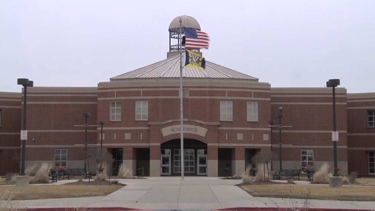 Wide shot of academics building at Neuqua Valley High School with flagpole in front -one of the 204 schools to have work done this summer