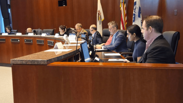 Naperville Public Utility Advisory Board seated at dais at meeting with IMEA presentation on power deal extention