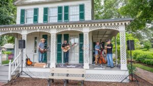 The Wood Street Bloodhounds band performing on porch at Naper Settlement Farmers Market