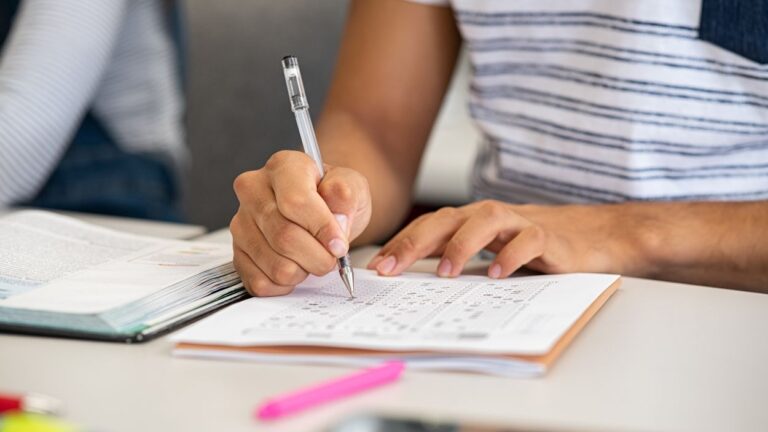 Close up of student filling in scantron form on desk for story on District 203 asssessment tool