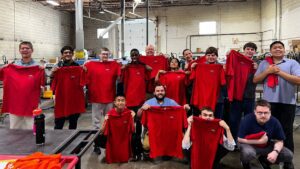 SparkForce campers hold up red tshirts