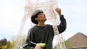Eric Klabel places a toothpick on his toothpick tower.