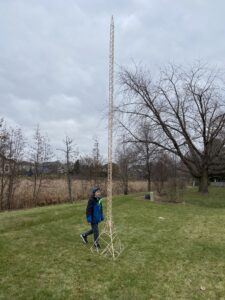 A young Eric Klabel walks alongside his popsicle stick tower