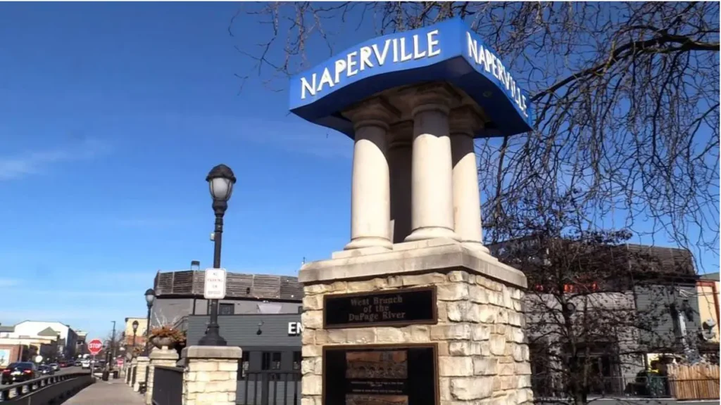 A blue city sign sits in downtown Naperville