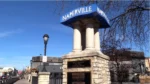 A blue city sign sits in downtown Naperville